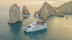CaboRey dinner cruise sailing beside the Arch of Cabo San Lucas at sunset